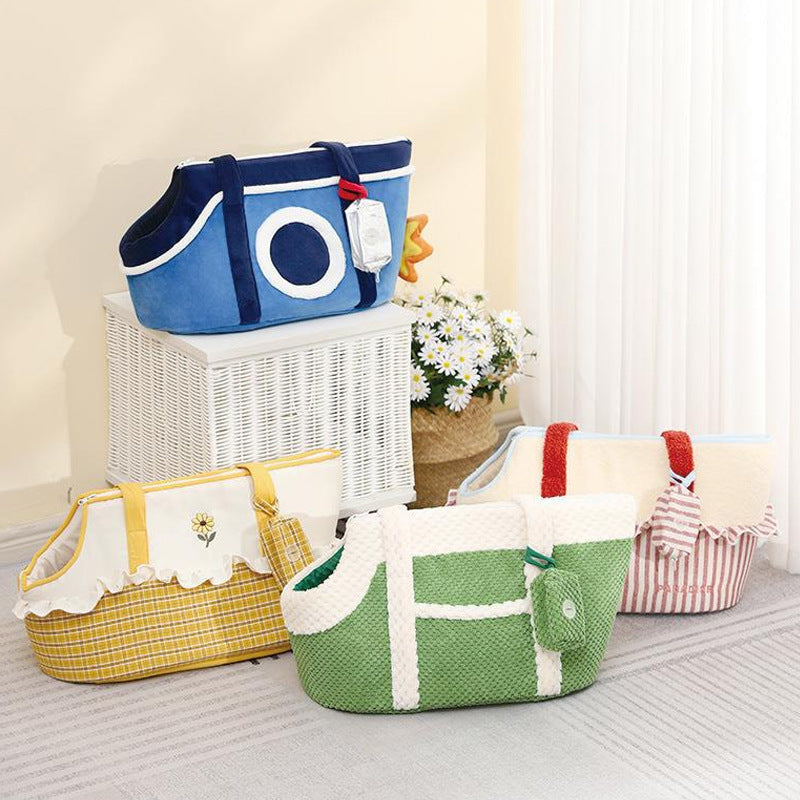 Four colorful Pet carry tote-Cartoon Pet Carrier Shoulder Bag for Cats & Small Dogs in blue, yellow, green, and red with decorative patterns displayed indoors on a white wicker stand and carpeted floor