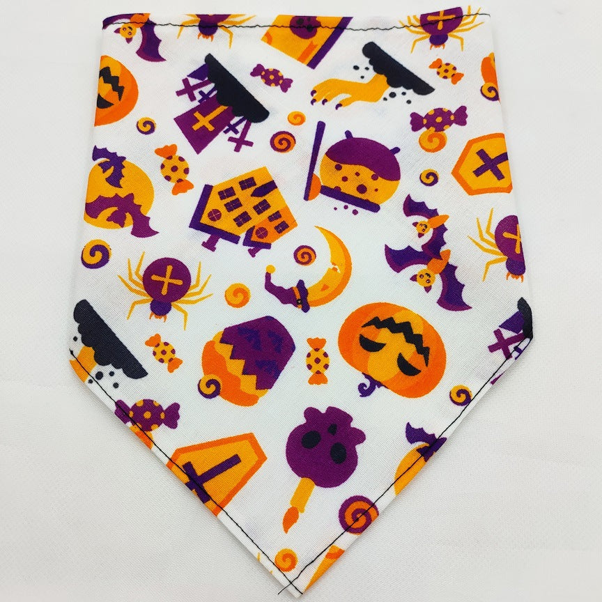 Pet Tie-Dye Triangle Bandana Scarf for Dogs & Cats featuring a playful Halloween pattern with pumpkins, bats, spiders, candy, and haunted houses in orange, purple, and black colors.