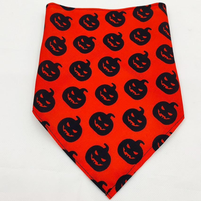 Pet Tie-Dye Triangle Bandana Scarf for Dogs & Cats in bright orange with a repeating pattern of black jack-o'-lantern faces, ideal for festive dog apparel and accessories.