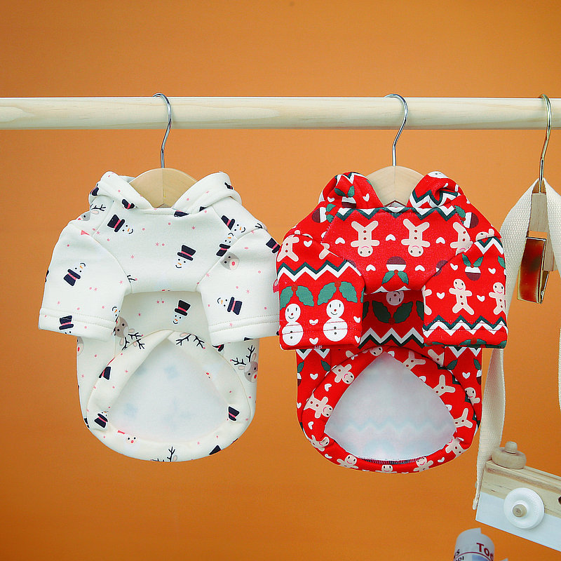 Dog Christmas Sweatshirt | Festive Holiday Clothes for Dogs featuring two holiday-themed hoodies, one white with snowmen and one red with gingerbread men and snowflakes, hanging on wooden hangers.