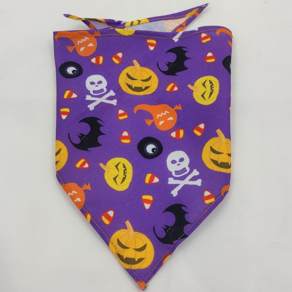 Pet Tie-Dye Triangle Bandana Scarf for Dogs & Cats with purple background featuring Halloween-themed prints including pumpkins, bats, ghosts, skulls, and candy corn for festive dog apparel.