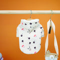 Dog Christmas Sweatshirt | Festive Holiday Clothes for Dogs in white with a cute winter pattern including Santa hats, snowmen, and reindeer antlers, hanging on a wooden rack.